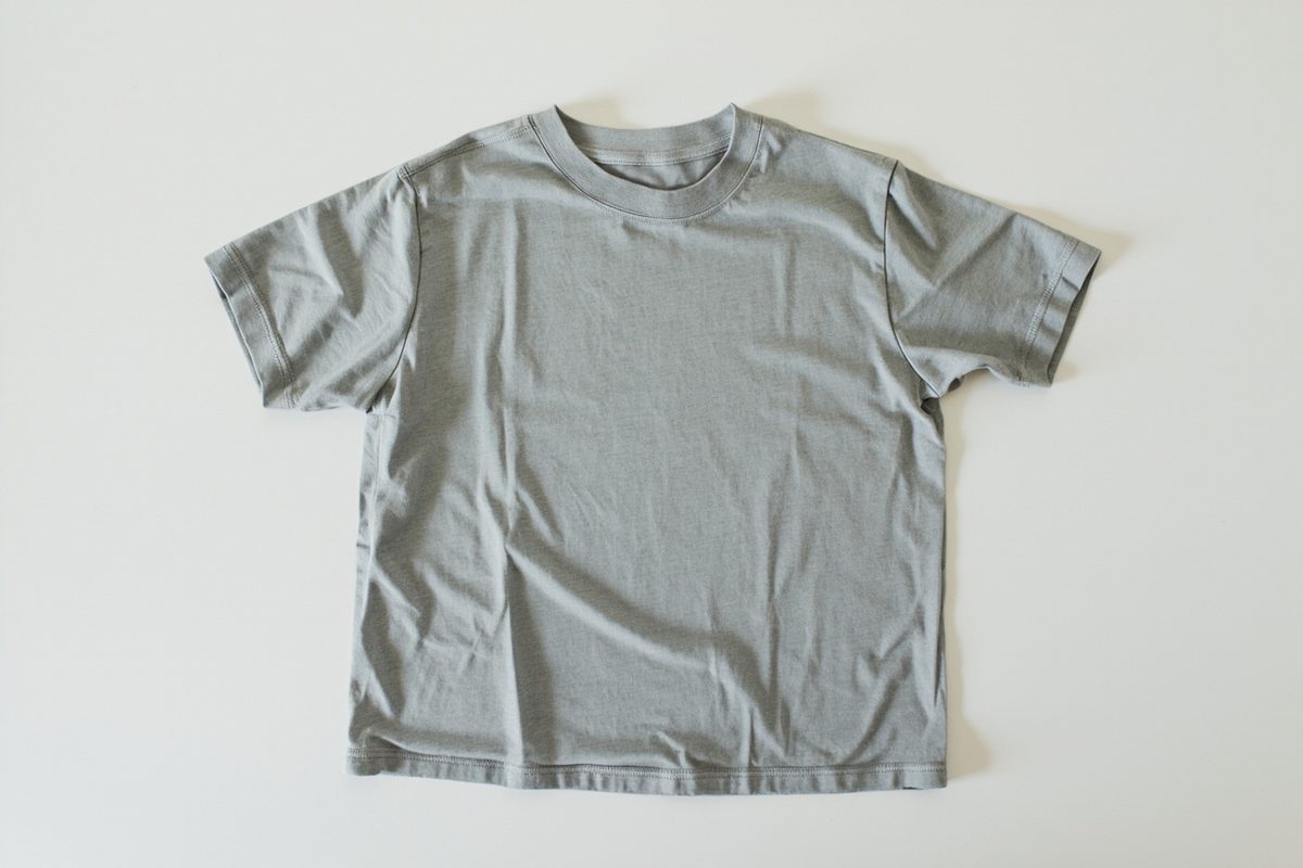 A plain grey t-shirt laid flat with smooth side edges and no side seam running down either side.